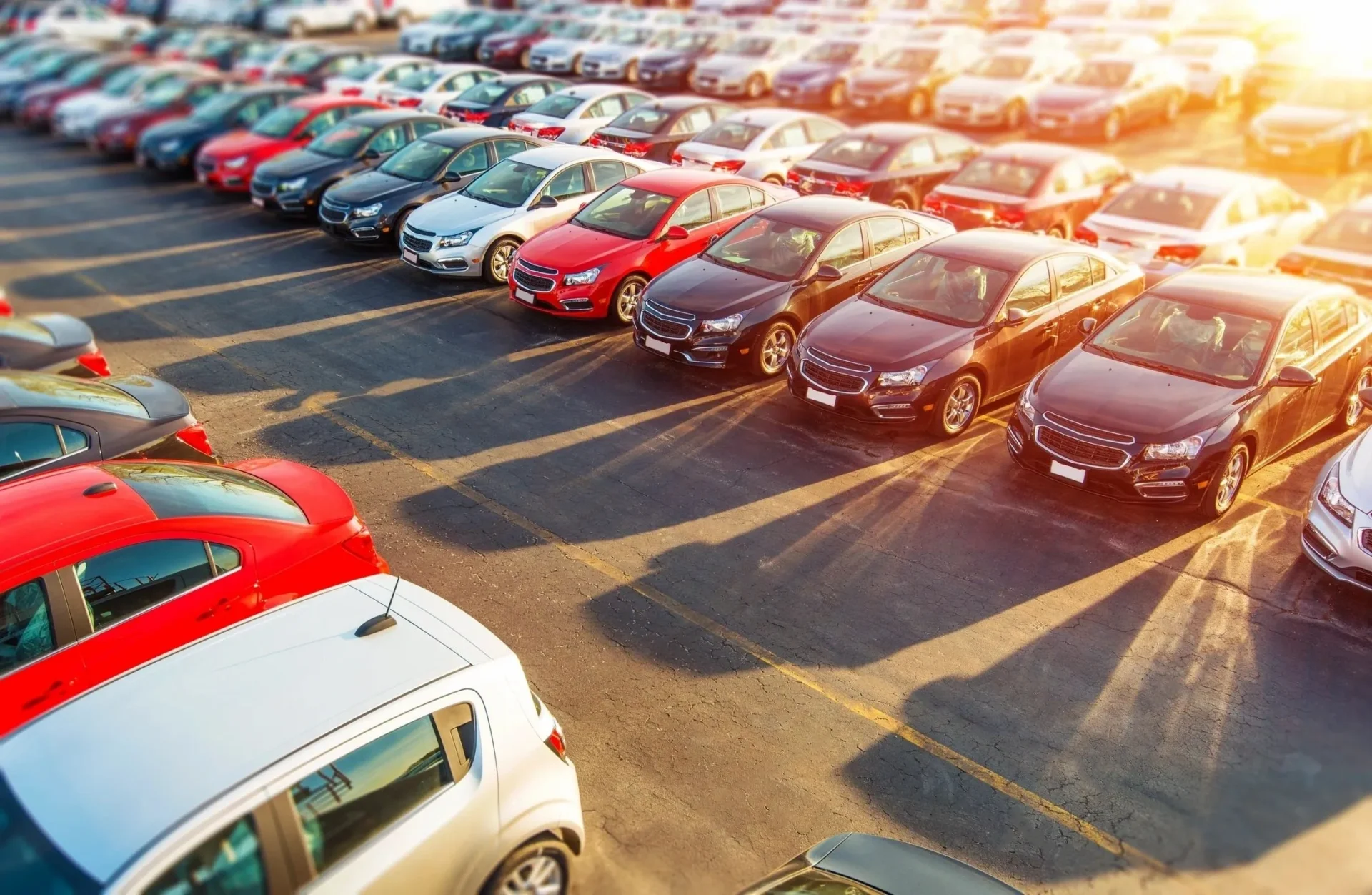 A parking lot filled with lots of cars parked in it.